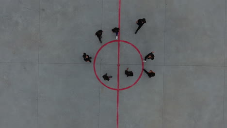 Group-of-kids-cheering-in-circle-drone-view.-Vertical-aerial